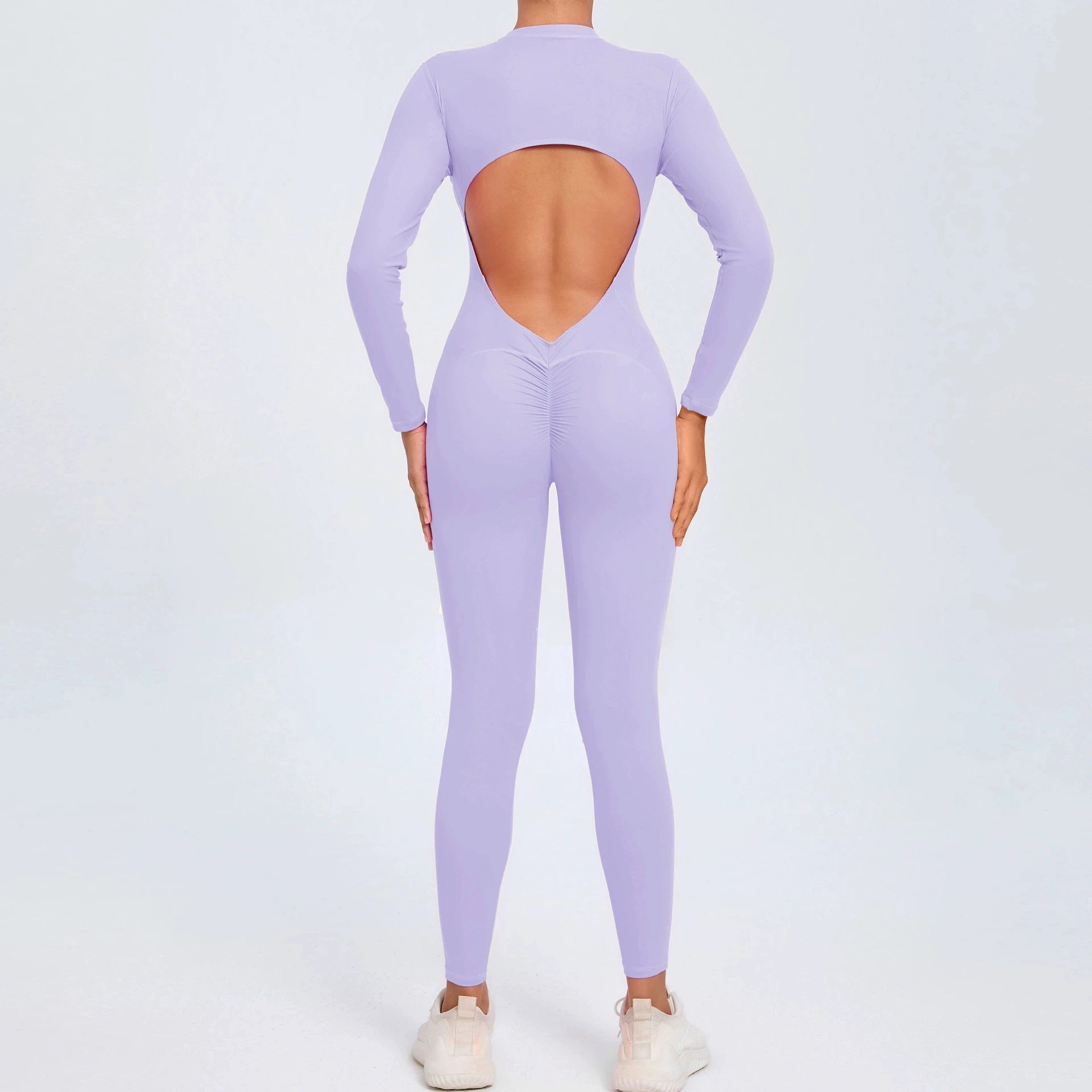Pastel purple backless long sleeve sports jumpsuit with front zipper designed for extreme comfort and confidence in the gym by allowing you to show off that pumped back