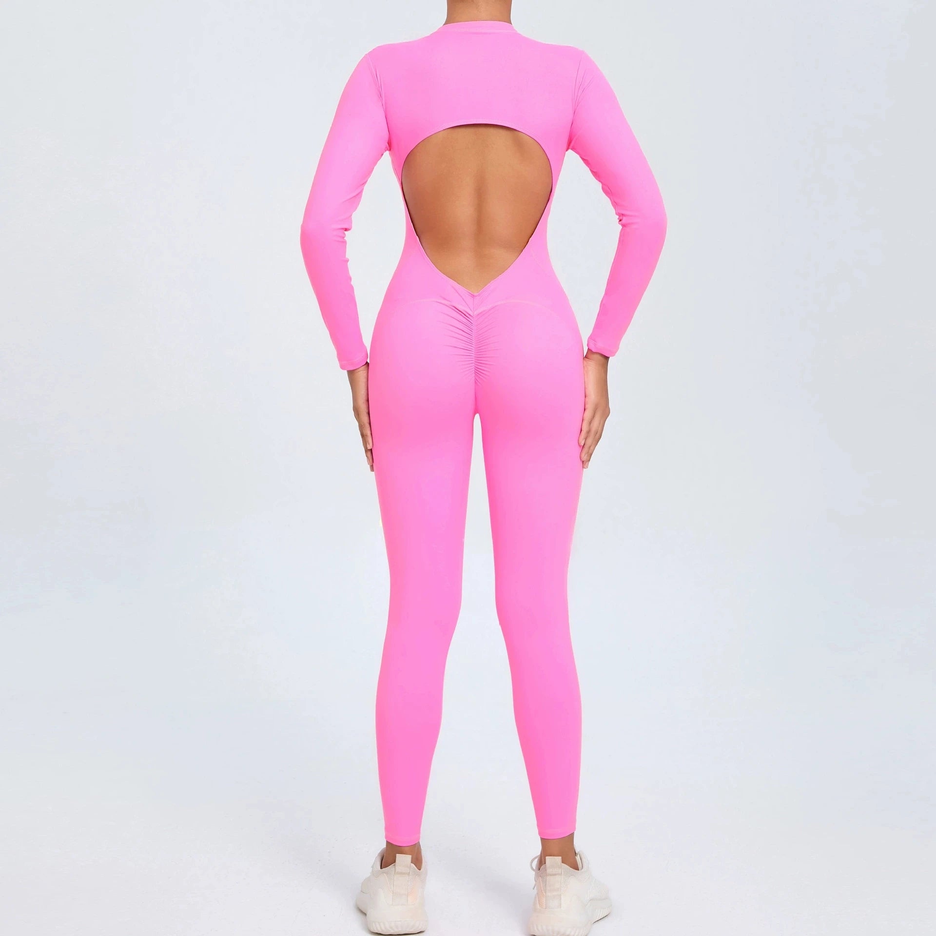 Pink backless long sleeve sports jumpsuit with front zipper designed for extreme comfort and confidence in the gym by allowing you to show off that pumped back
